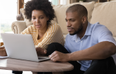 Photo of two adults looking at a laptop to represent stakeholder feedback survey on blended and online learning 