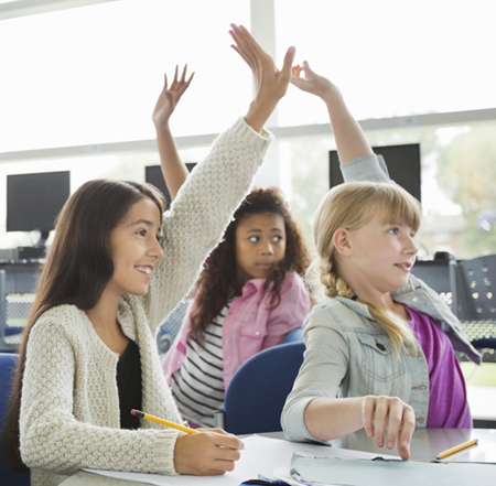 Three students raising their hands in a classroom